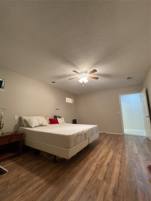 unfurnished bedroom with a textured ceiling, ceiling fan, and hardwood / wood-style flooring