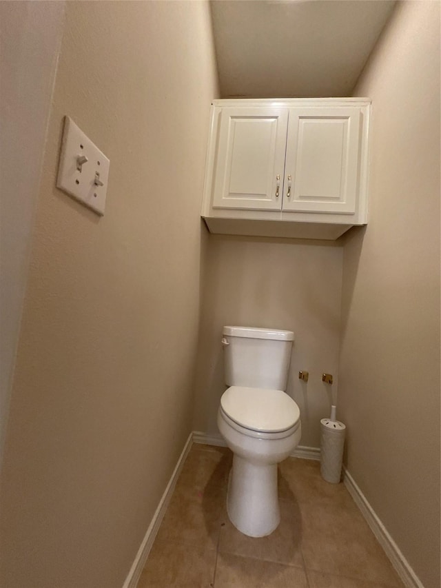 bathroom featuring tile patterned flooring, toilet, and baseboards