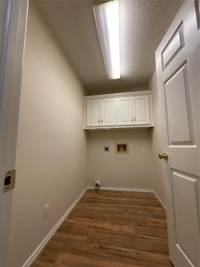 clothes washing area featuring cabinet space, baseboards, dark wood-type flooring, hookup for a washing machine, and hookup for an electric dryer