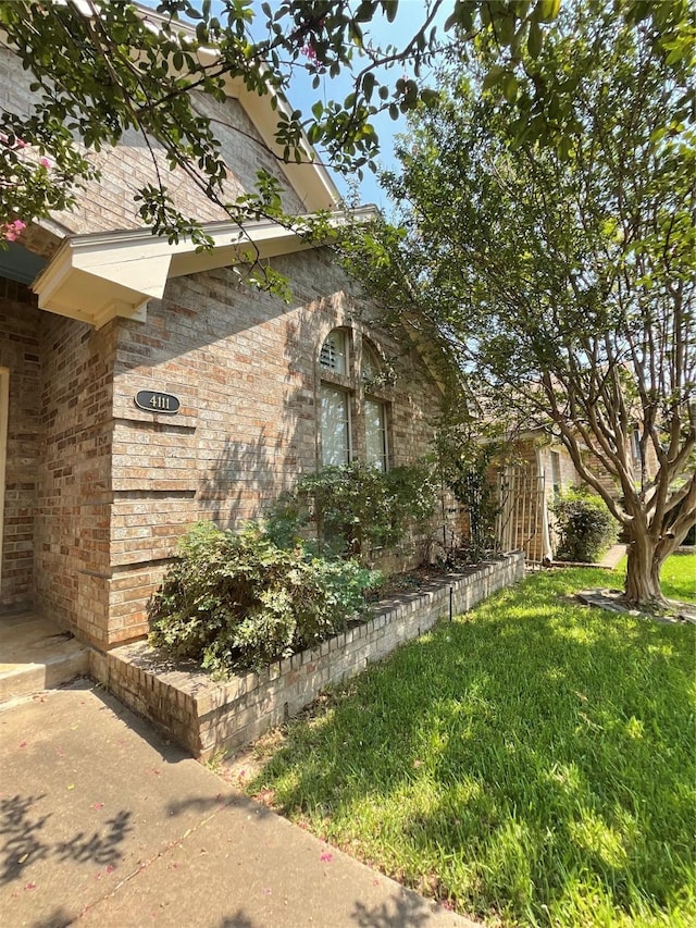 view of home's exterior featuring a yard and brick siding