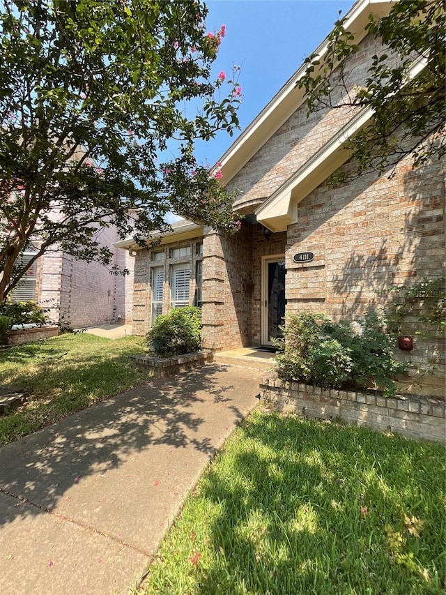 view of exterior entry with brick siding