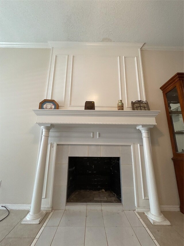 interior details with a textured ceiling, a tiled fireplace, and tile patterned floors