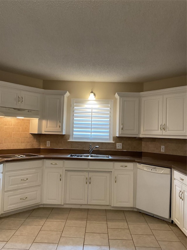 kitchen featuring dark countertops, white dishwasher, and a sink