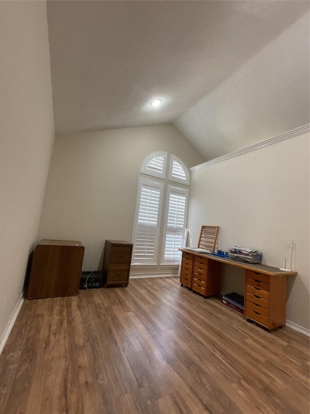 unfurnished office with lofted ceiling, dark wood-style floors, and baseboards