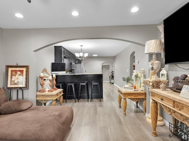 living room featuring light hardwood / wood-style floors and a notable chandelier