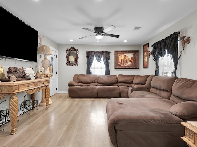 living room with light hardwood / wood-style flooring and ceiling fan