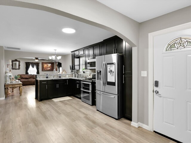 kitchen featuring appliances with stainless steel finishes, light hardwood / wood-style flooring, pendant lighting, and a wealth of natural light