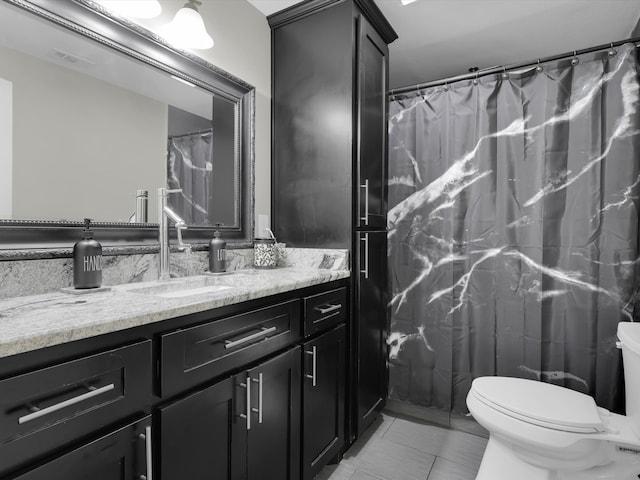 bathroom with vanity, tile patterned flooring, and toilet