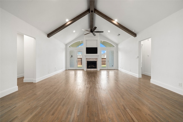 unfurnished living room with beamed ceiling, ceiling fan, dark wood-type flooring, and high vaulted ceiling