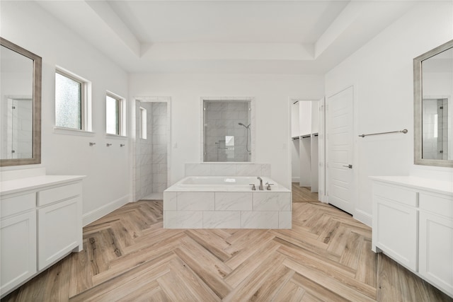 bathroom with parquet flooring, a raised ceiling, vanity, and separate shower and tub