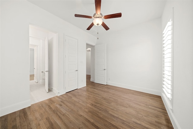 unfurnished bedroom featuring multiple windows, light wood-type flooring, and ceiling fan