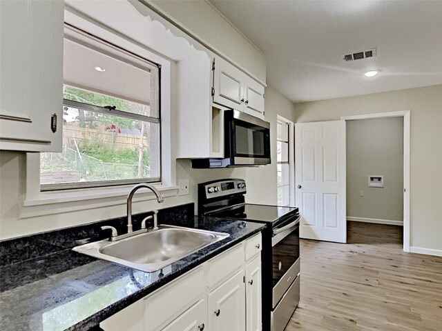 kitchen with white cabinetry, visible vents, a sink, and stainless steel appliances