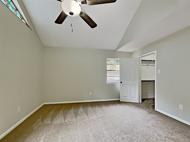 carpeted empty room with vaulted ceiling and ceiling fan