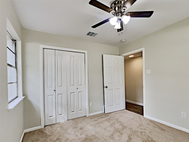 unfurnished bedroom with carpet, baseboards, visible vents, a ceiling fan, and a closet