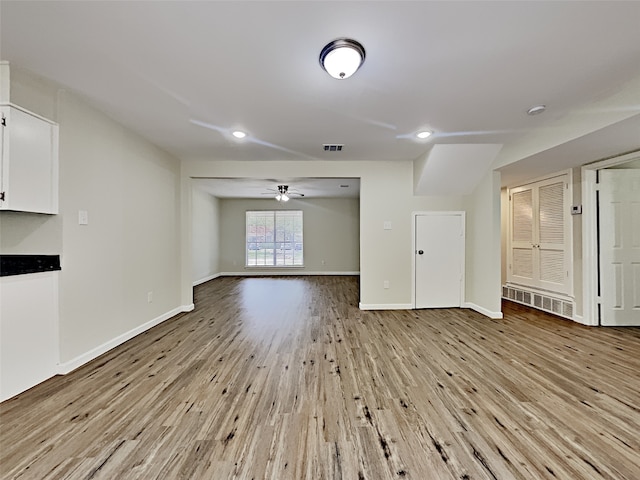 spare room with baseboards, visible vents, wood finished floors, and ceiling fan