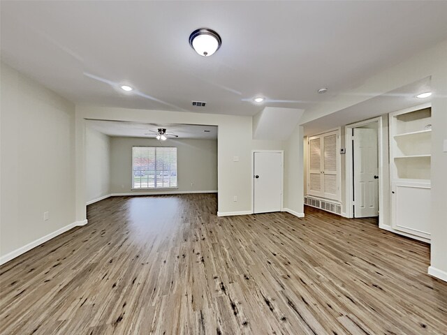 unfurnished living room featuring ceiling fan and light wood-type flooring