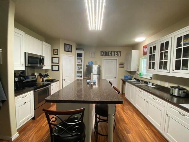 kitchen with white cabinets, a breakfast bar area, a center island, and appliances with stainless steel finishes