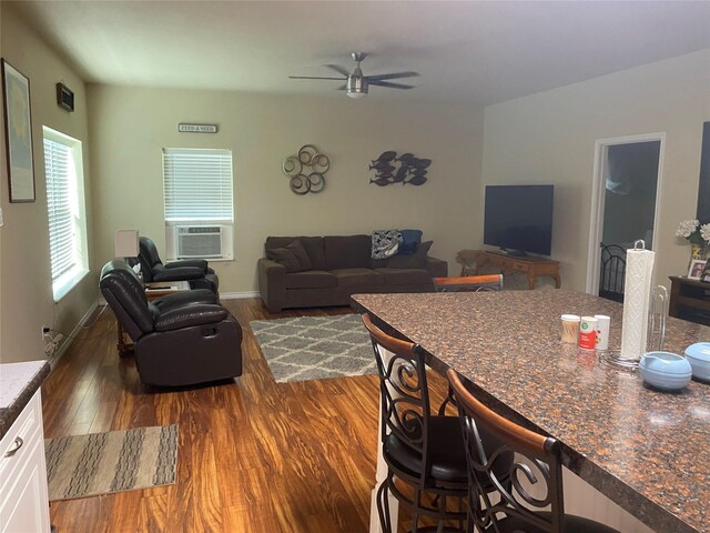 living room with cooling unit, ceiling fan, and dark hardwood / wood-style flooring