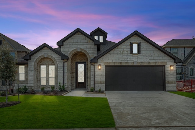 french country style house featuring a yard and a garage