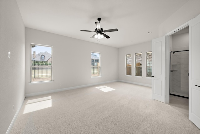 unfurnished bedroom with light colored carpet, baseboards, and ceiling fan