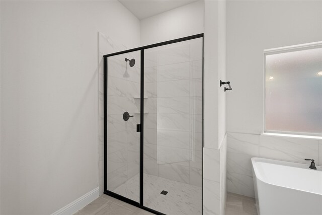 bathroom featuring a freestanding bath, tile walls, and a stall shower