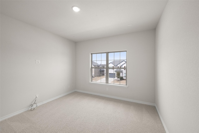 empty room featuring recessed lighting, carpet, and baseboards