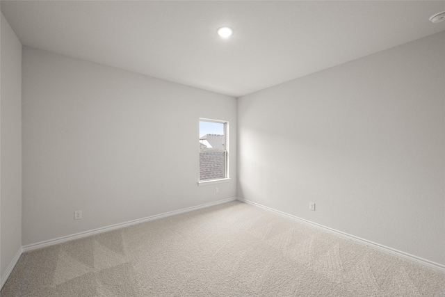 carpeted empty room featuring recessed lighting and baseboards