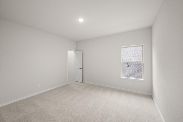 unfurnished room with recessed lighting, baseboards, and light carpet