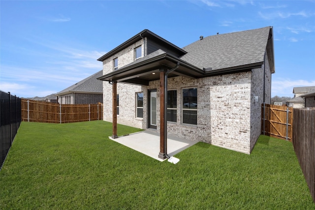 back of property with a yard, brick siding, a fenced backyard, and a patio area