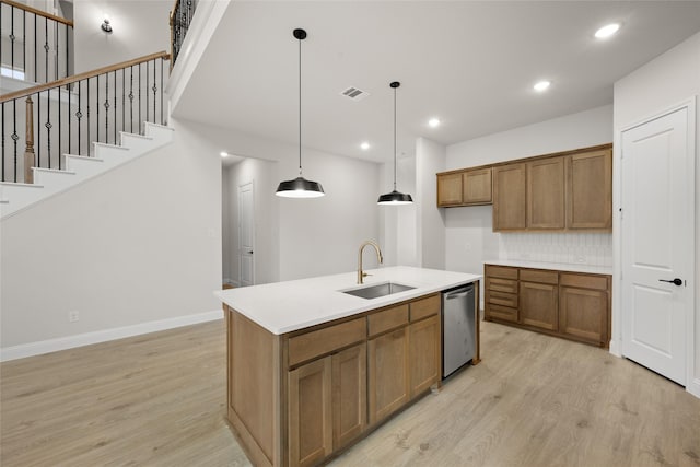 kitchen with brown cabinetry, visible vents, dishwasher, and a sink