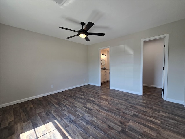 unfurnished bedroom featuring ensuite bath, ceiling fan, and dark hardwood / wood-style floors