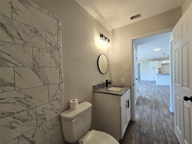 bathroom with wood-type flooring, toilet, and vanity