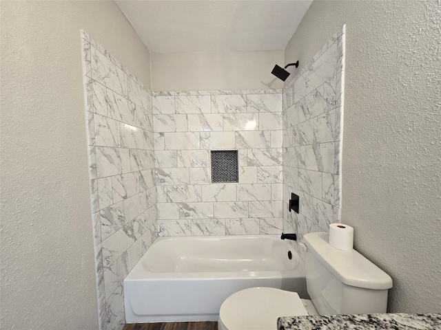 bathroom featuring toilet, tiled shower / bath, and hardwood / wood-style flooring