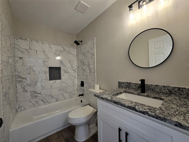 full bathroom with toilet, tiled shower / bath combo, vanity, and hardwood / wood-style floors