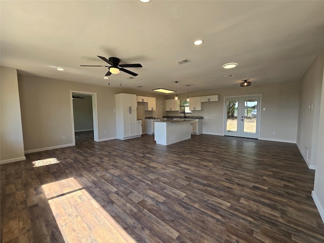 unfurnished living room featuring ceiling fan, dark wood-type flooring, and french doors