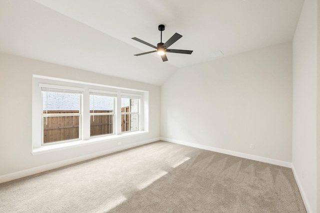 carpeted empty room with vaulted ceiling and ceiling fan