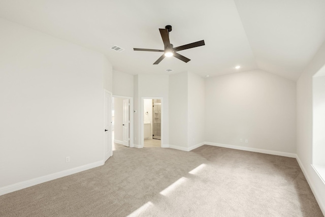 unfurnished bedroom with ceiling fan, light colored carpet, lofted ceiling, and connected bathroom