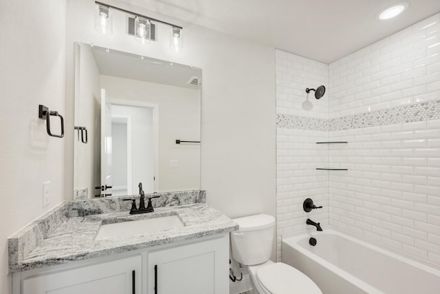 full bathroom with tiled shower / bath, vanity, and toilet