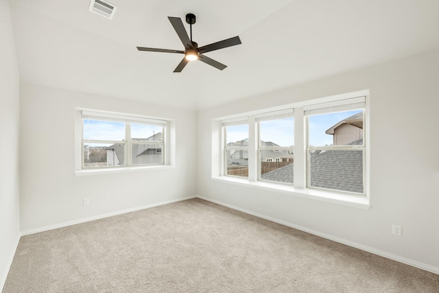 carpeted spare room with ceiling fan and a wealth of natural light