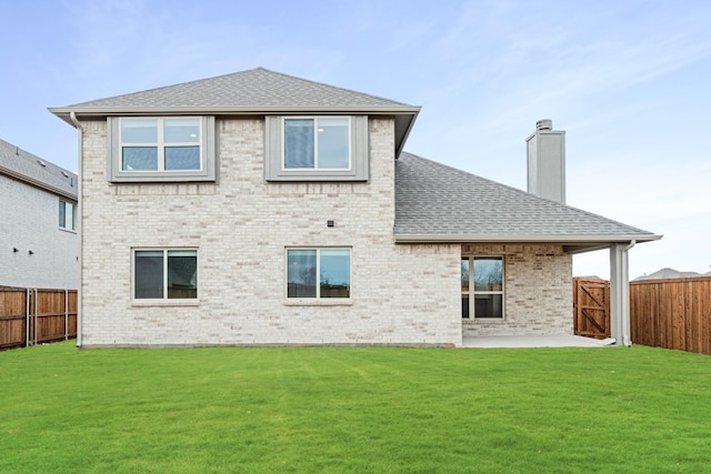 rear view of property featuring a patio and a lawn