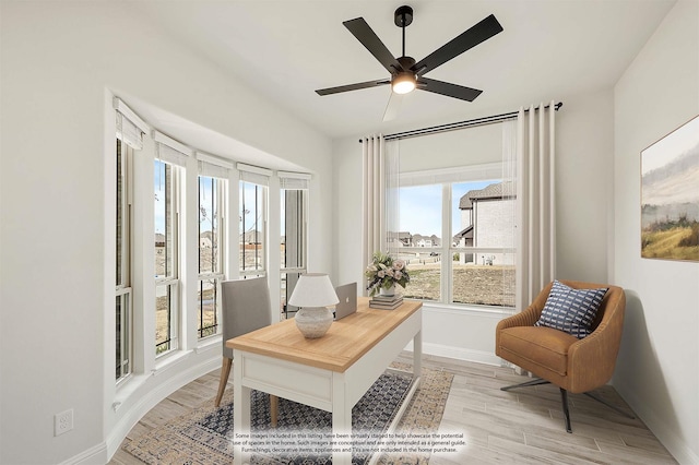 office with light hardwood / wood-style flooring and ceiling fan