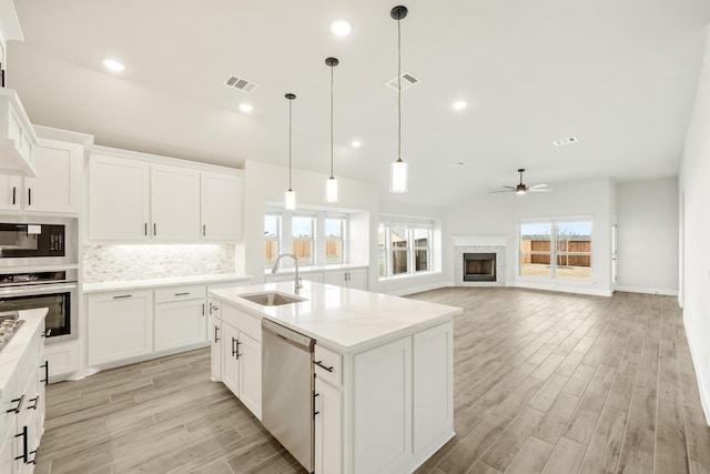 kitchen featuring white cabinetry, an island with sink, stainless steel appliances, and sink