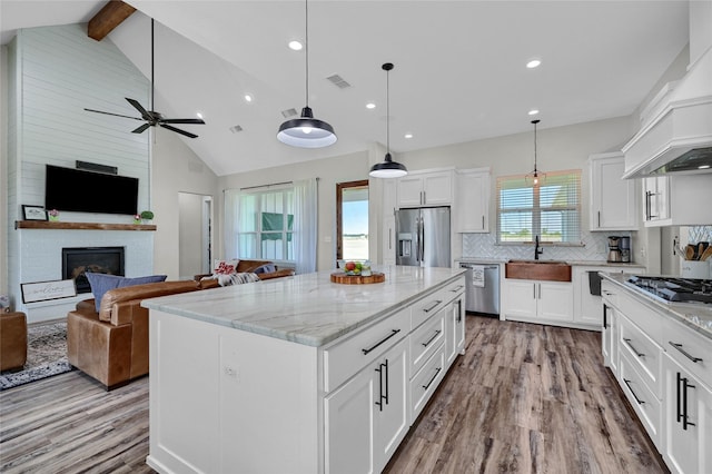 kitchen featuring visible vents, stainless steel appliances, a sink, and open floor plan