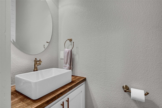 bathroom with vanity and a textured wall