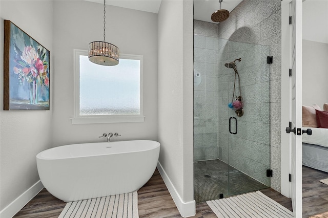 bathroom with a stall shower, baseboards, and wood finished floors