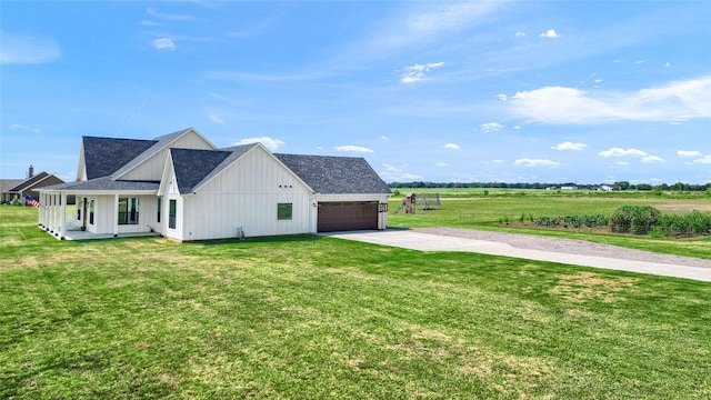 view of side of home featuring an attached garage, driveway, a lawn, roof with shingles, and board and batten siding