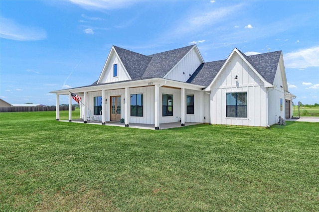 view of front of property with board and batten siding, roof with shingles, and a front lawn