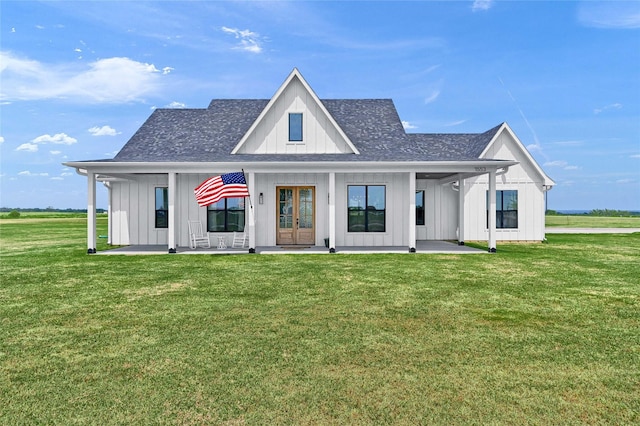 modern farmhouse style home with french doors, board and batten siding, a front yard, and a shingled roof