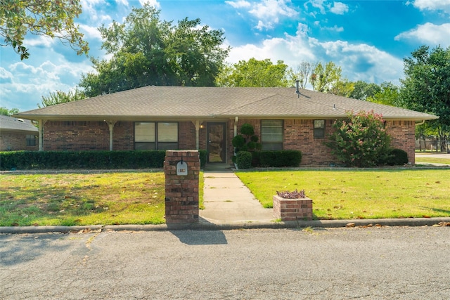 ranch-style house featuring a front lawn, a shingled roof, and brick siding