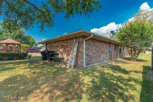 view of side of home featuring a gazebo and a yard